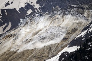 KEYPIX - Une vue montre des blocs de glace qui se detachent du glacier du Birch au-dessus de Blatten le mercredi 28 mai 2025 depuis un alpage au-dessus de Wiler. Plusieurs avalanches avec des debris de glace, de roches et de neige descendent du glacier de Birch dans le Loetschental mais n'ont pas atteint le village de Blatten. Les debris ont glisse jusqu'a un barrage anti-avalanches. (KEYSTONE/Jean-Christophe Bott)