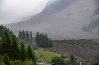 A large avalanche with a mixture of ice, rock, snow and water reach the valley floor is pictured in Wiler after the Birch glacier collapsing above Blatten, Switzerland, Wednesday, May 28, 2025. A large part of the village of Blatten in the Valais Loetschental was buried under the masses of ice, mud and rock. Numerous houses were destroyed, but no people were harmed. On the Kleiner Nesthorn above Blatten, several million cubic metres of rock collapsed between 19 and 28 May. A nine million tonne cone of rubble formed on the Birch Glacier below, which broke on 28 May 2025. (KEYSTONE/Jean-Christophe Bott)