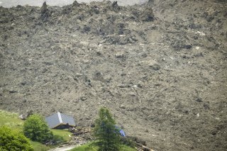 A large avalanche with a mixture of ice, rock, snow and water reach the valley floor is pictured in Wiler after the Birch glacier collapsing above Blatten, Switzerland, Wednesday, May 28, 2025. (Jean-Christophe Bott/Keystone via AP) Switzerland Mudslide