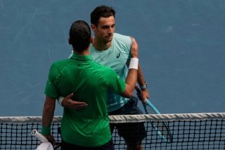 Novak Djokovic (de dos) a bénéficié de l'abandon de Lorenzo Musetti. KEYSTONE/AP/Aaron Favila